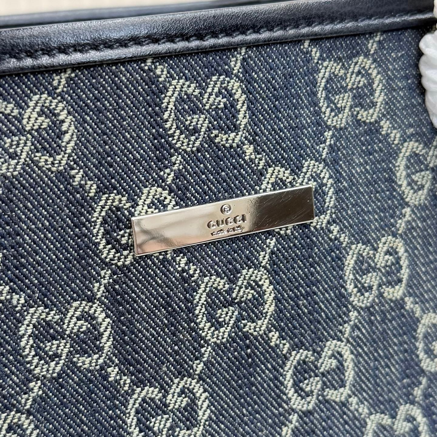 Generation Gucci系列深入探索品牌典藏元素，将不同世代的设计融合成一种美学叙事。GG牛仔布为精致廓形增添品牌标志性元素。这款托特包通过品牌标识徽饰将日常风格提升至新高度，内部配有拉链口袋。