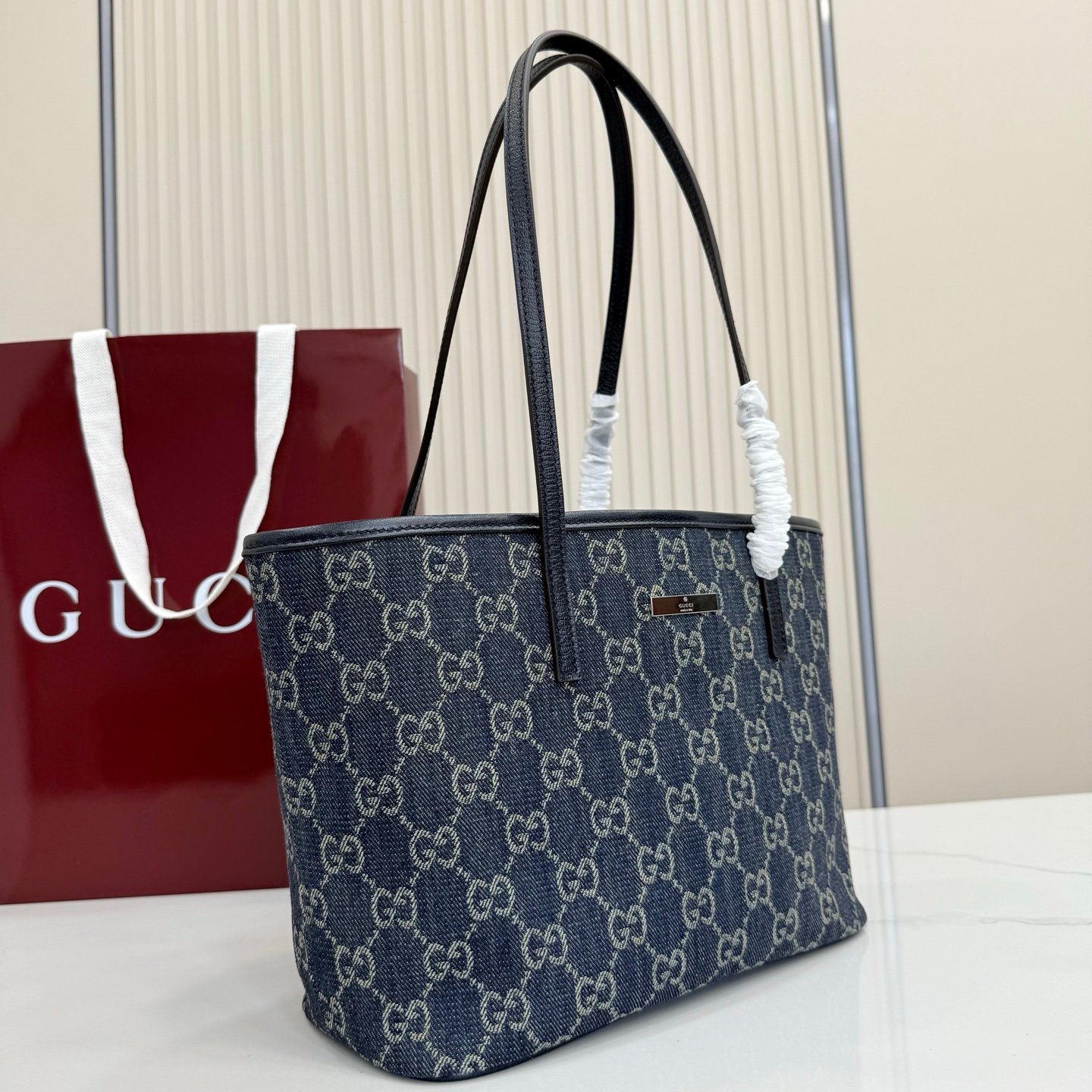 Generation Gucci系列深入探索品牌典藏元素，将不同世代的设计融合成一种美学叙事。GG牛仔布为精致廓形增添品牌标志性元素。这款托特包通过品牌标识徽饰将日常风格提升至新高度，内部配有拉链口袋。