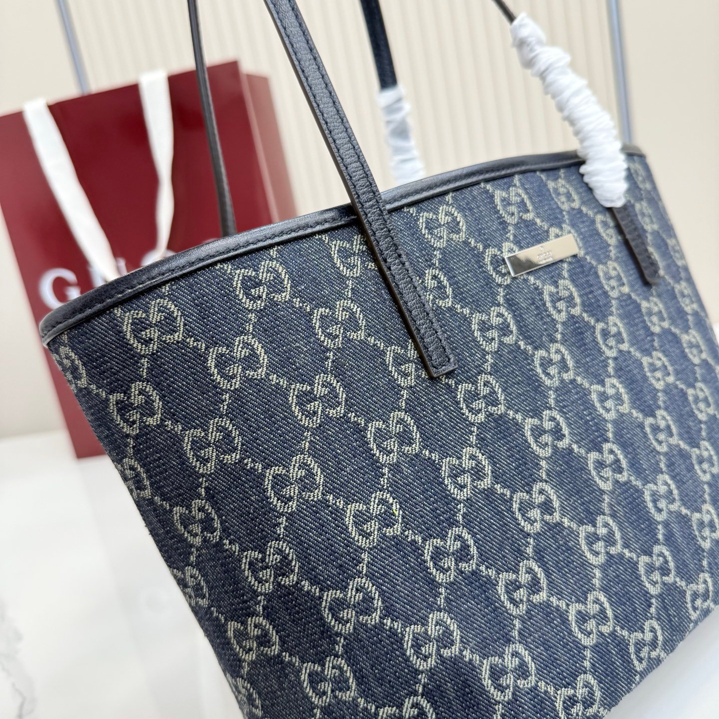 Generation Gucci系列深入探索品牌典藏元素，将不同世代的设计融合成一种美学叙事。GG牛仔布为精致廓形增添品牌标志性元素。这款托特包通过品牌标识徽饰将日常风格提升至新高度，内部配有拉链口袋。