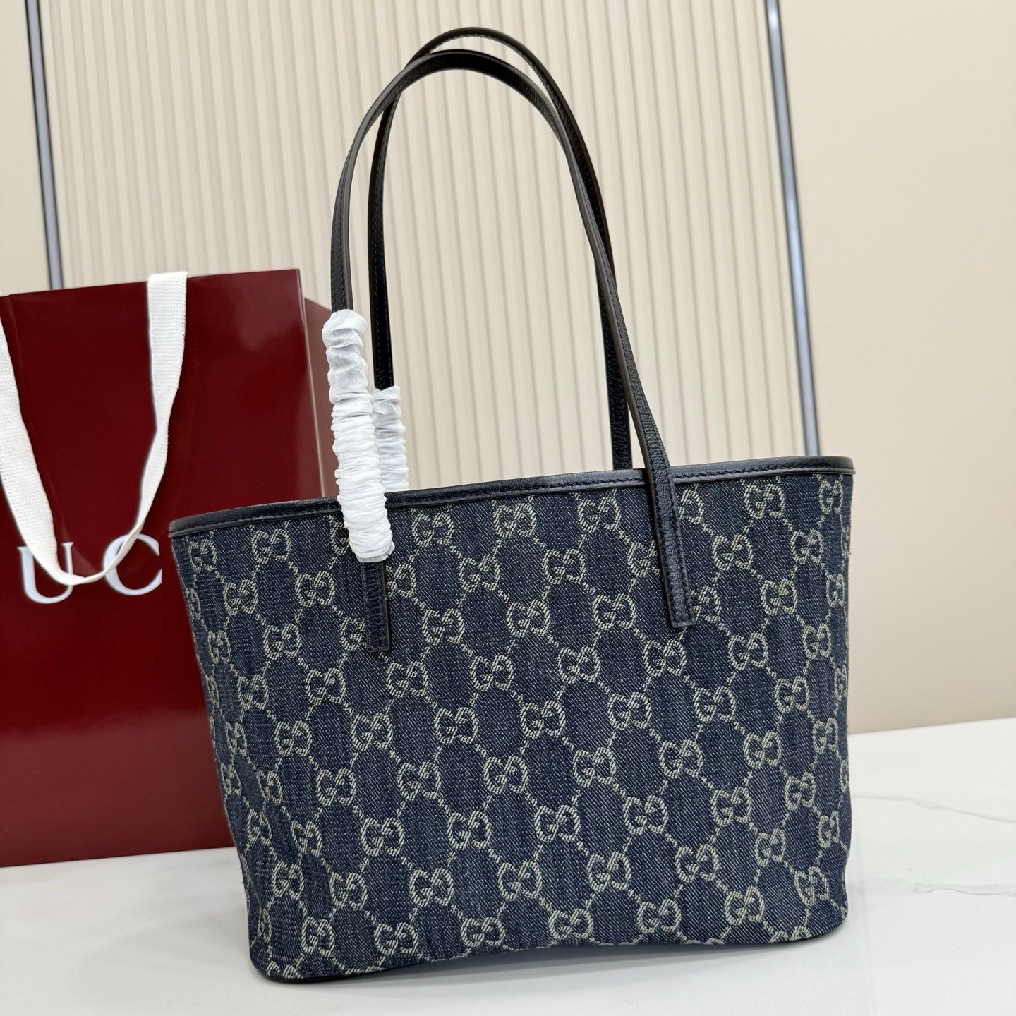 Generation Gucci系列深入探索品牌典藏元素，将不同世代的设计融合成一种美学叙事。GG牛仔布为精致廓形增添品牌标志性元素。这款托特包通过品牌标识徽饰将日常风格提升至新高度，内部配有拉链口袋。
