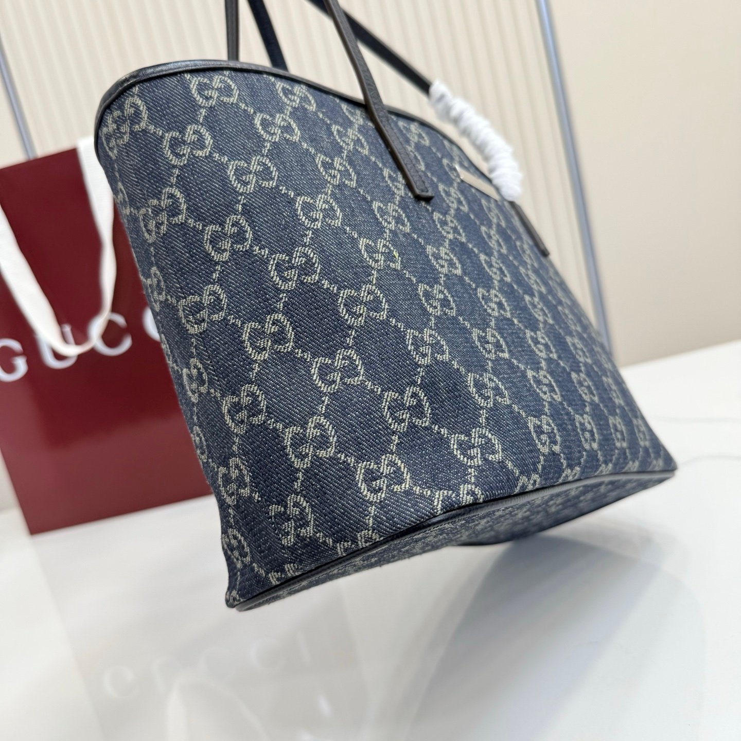 Generation Gucci系列深入探索品牌典藏元素，将不同世代的设计融合成一种美学叙事。GG牛仔布为精致廓形增添品牌标志性元素。这款托特包通过品牌标识徽饰将日常风格提升至新高度，内部配有拉链口袋。