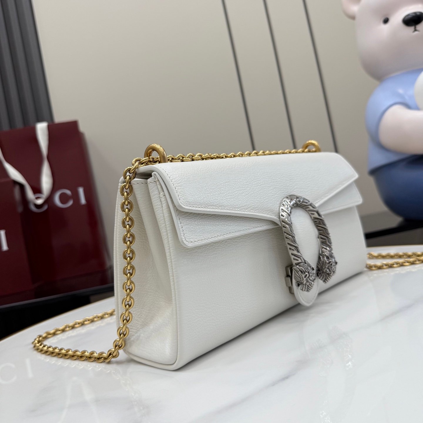 配全套原厂专柜包装 Generation Gucci系列深入探索品牌的典藏元素,将不同年代的设计融合成一种美学叙事。Dionysus 系列引入柔软的角撑结构和双色五金配件。标志性虎头和新款链条肩带的金属饰面为每种款式变化增添独特风情。这款单