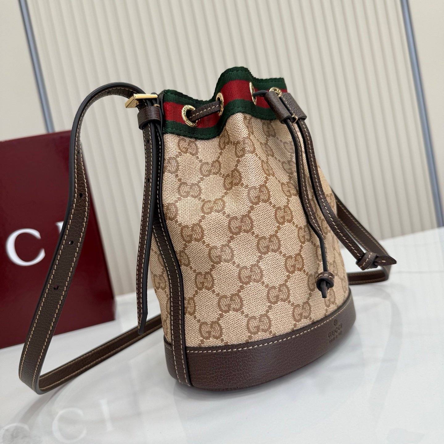 Generation Gucci古驰世代系列深入探索品牌的典藏元素，将不同世代的设计融合为统一的美学叙事。GG涂层帆布搭配经典织带，为多功能小型皮具带来标志性风格，如这款设计用于存放日常必需品的水桶包。