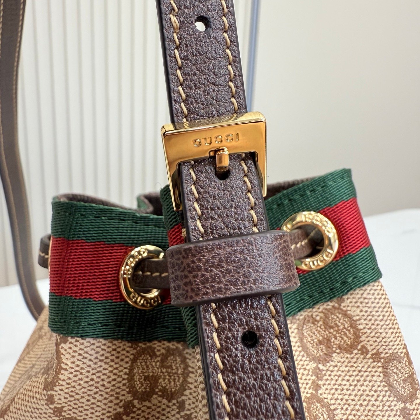 Generation Gucci古驰世代系列深入探索品牌的典藏元素，将不同世代的设计融合为统一的美学叙事。GG涂层帆布搭配经典织带，为多功能小型皮具带来标志性风格，如这款设计用于存放日常必需品的水桶包。