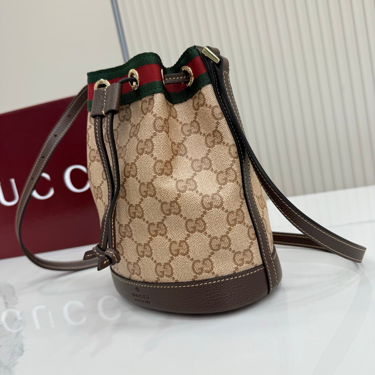 Generation Gucci古驰世代系列深入探索品牌的典藏元素，将不同世代的设计融合为统一的美学叙事。GG涂层帆布搭配经典织带，为多功能小型皮具带来标志性风格，如这款设计用于存放日常必需品的水桶包。