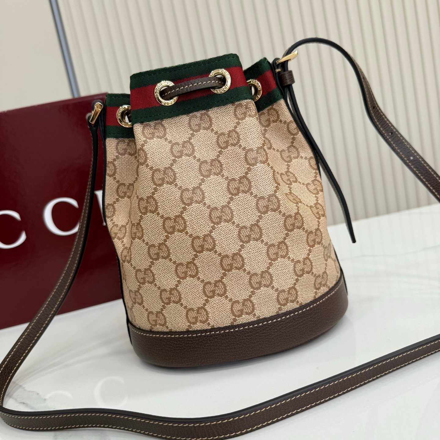 Generation Gucci古驰世代系列深入探索品牌的典藏元素，将不同世代的设计融合为统一的美学叙事。GG涂层帆布搭配经典织带，为多功能小型皮具带来标志性风格，如这款设计用于存放日常必需品的水桶包。
