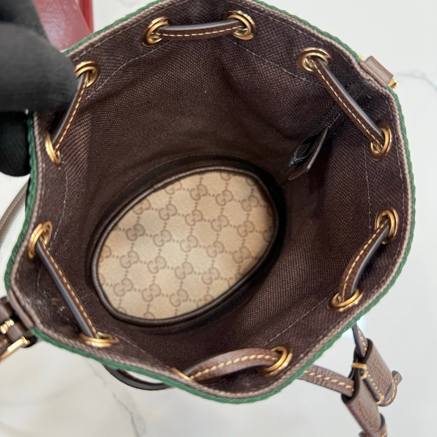 Generation Gucci古驰世代系列深入探索品牌的典藏元素，将不同世代的设计融合为统一的美学叙事。GG涂层帆布搭配经典织带，为多功能小型皮具带来标志性风格，如这款设计用于存放日常必需品的水桶包。