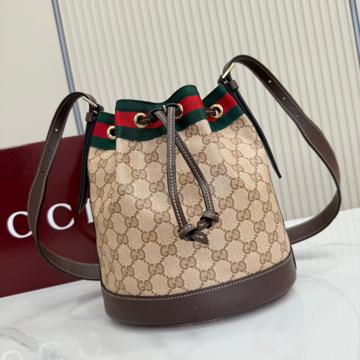 Generation Gucci系列深入探索品牌的经典元素，将不同世代的设计融合成一种美学叙事。GG涂层帆布搭配织带，为多功能小型皮具带来品牌标志性的设计，例如这款设计用于存放日常必需品的水桶包。