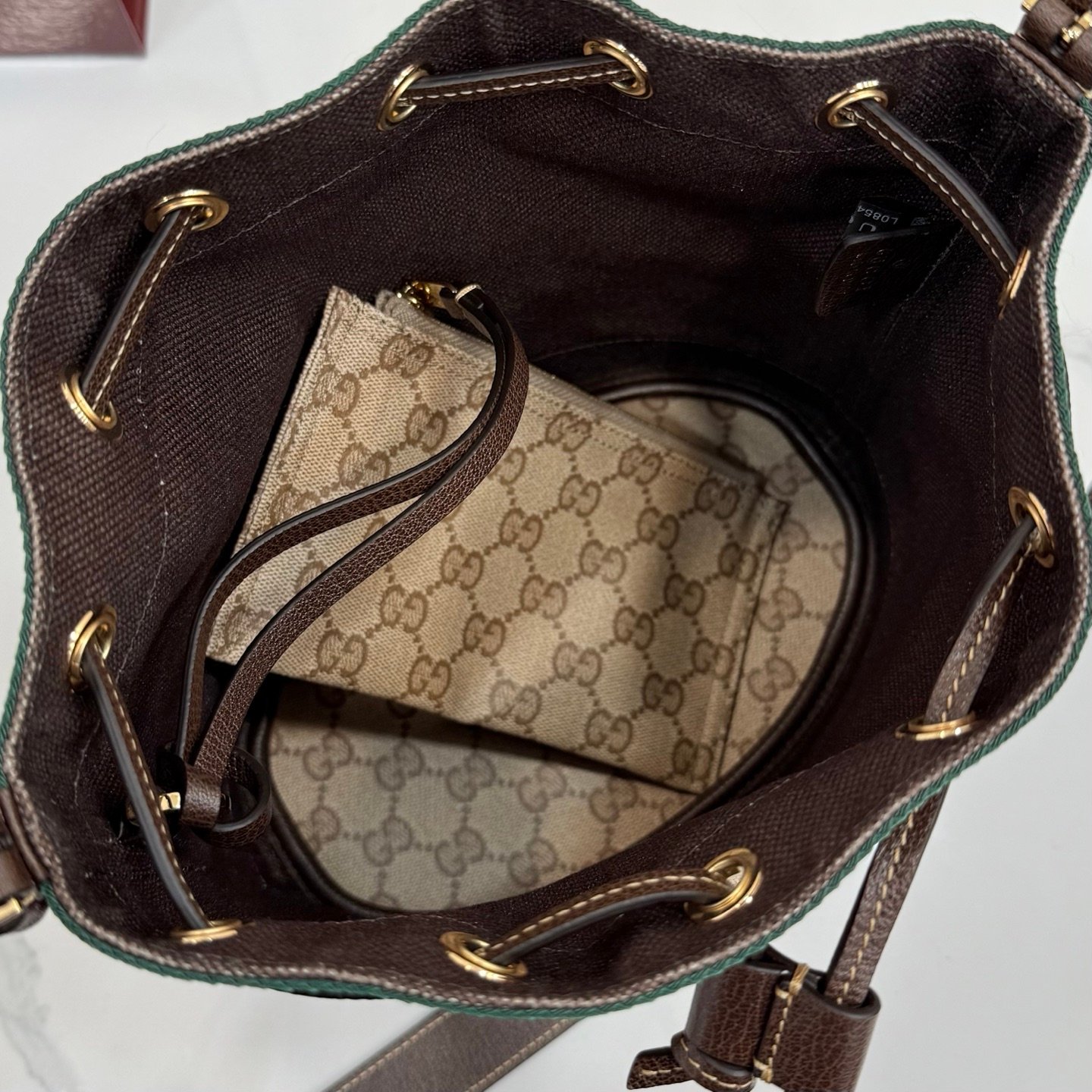 Generation Gucci系列深入探索品牌的经典元素，将不同世代的设计融合成一种美学叙事。GG涂层帆布搭配织带，为多功能小型皮具带来品牌标志性的设计，例如这款设计用于存放日常必需品的水桶包。