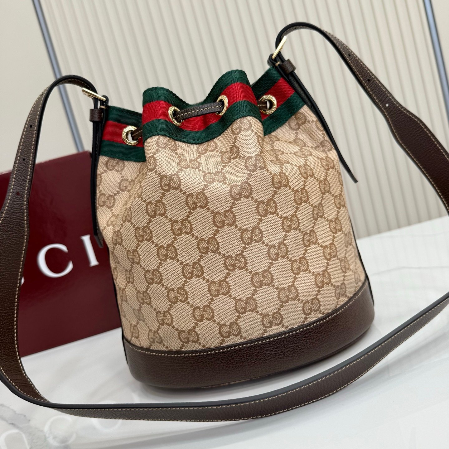 Generation Gucci系列深入探索品牌的经典元素，将不同世代的设计融合成一种美学叙事。GG涂层帆布搭配织带，为多功能小型皮具带来品牌标志性的设计，例如这款设计用于存放日常必需品的水桶包。