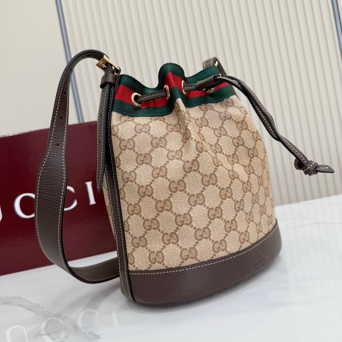 Generation Gucci系列深入探索品牌的经典元素，将不同世代的设计融合成一种美学叙事。GG涂层帆布搭配织带，为多功能小型皮具带来品牌标志性的设计，例如这款设计用于存放日常必需品的水桶包。