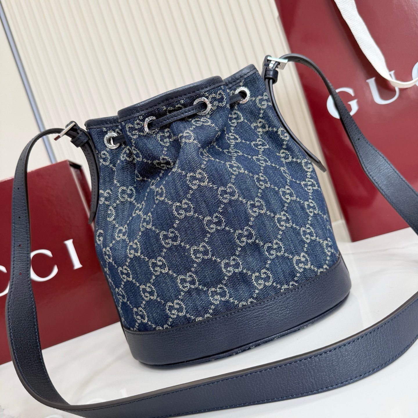 Generation Gucci系列深入探索品牌的典藏元素，将不同世代的设计融合成一种美学叙事。GG牛仔布为多功能小型皮具带来品牌标志性的点缀，比如这款设计用于存放日常必需品的水桶包。