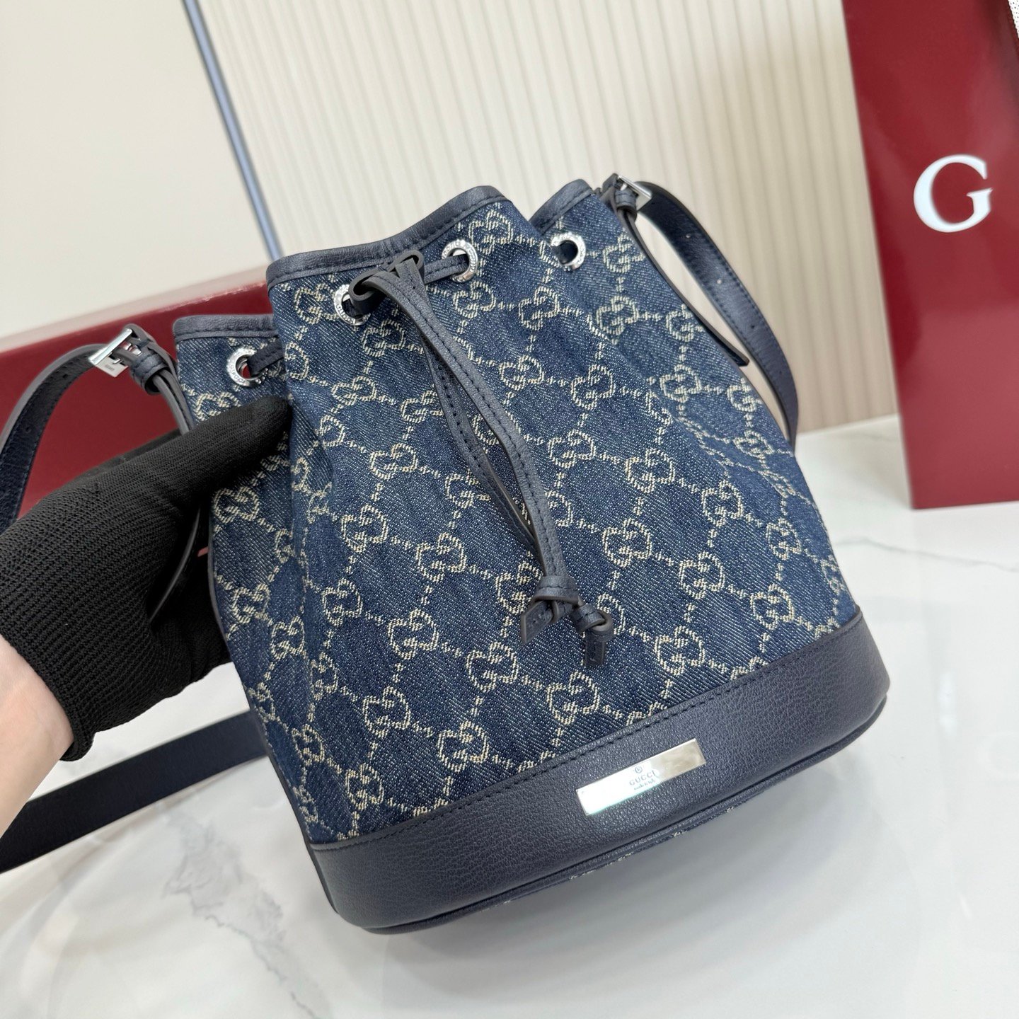Generation Gucci系列深入探索品牌的典藏元素，将不同世代的设计融合成一种美学叙事。GG牛仔布为多功能小型皮具带来品牌标志性的点缀，比如这款设计用于存放日常必需品的水桶包。