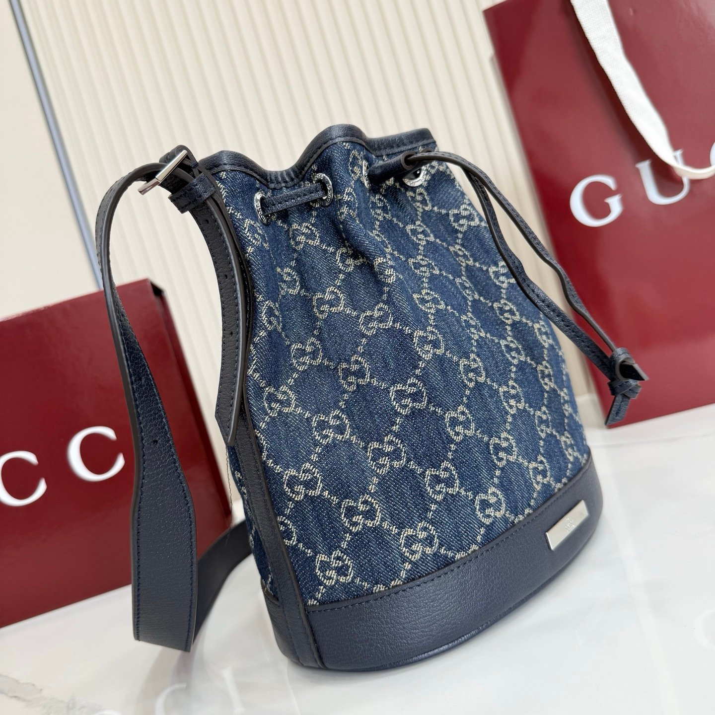 Generation Gucci系列深入探索品牌的典藏元素，将不同世代的设计融合成一种美学叙事。GG牛仔布为多功能小型皮具带来品牌标志性的点缀，比如这款设计用于存放日常必需品的水桶包。
