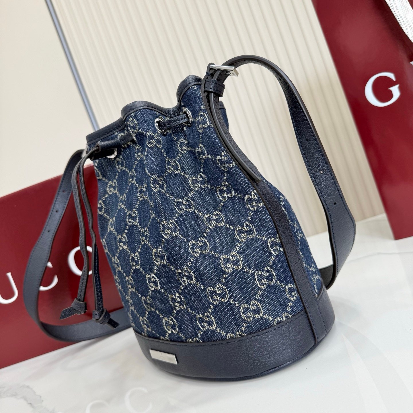 Generation Gucci系列深入探索品牌的典藏元素，将不同世代的设计融合成一种美学叙事。GG牛仔布为多功能小型皮具带来品牌标志性的点缀，比如这款设计用于存放日常必需品的水桶包。