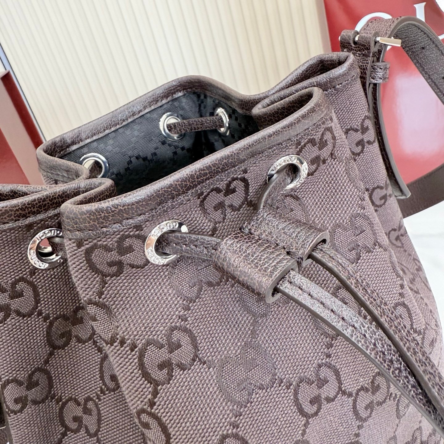 Generation Gucci系列深入探索品牌的典藏元素，将不同世代的设计融合成一种美学叙事。GG深棕色帆布为多功能小型皮具带来品牌标志性的点缀，比如这款设计用于存放日常必需品的水桶包。