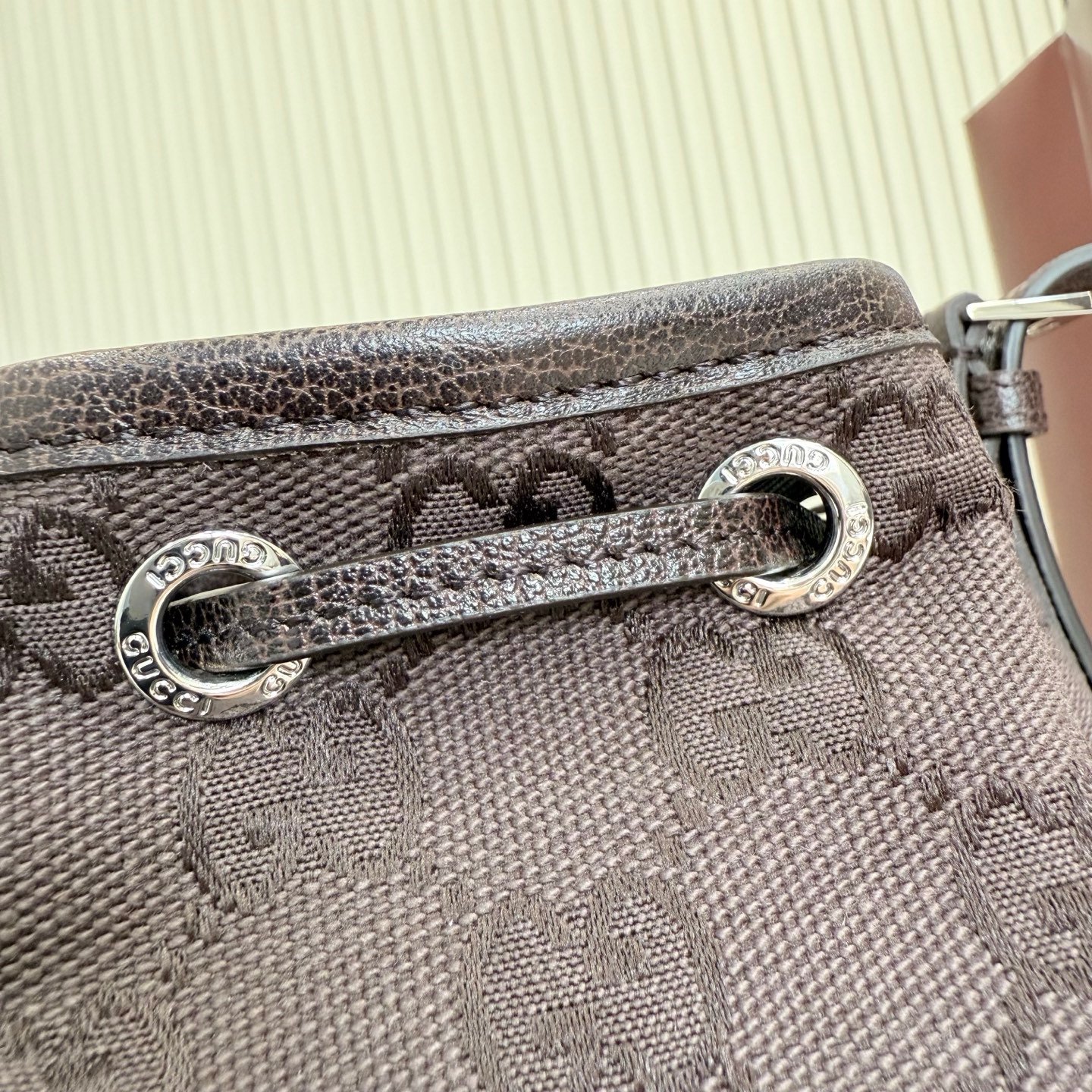 Generation Gucci系列深入探索品牌的典藏元素，将不同世代的设计融合成一种美学叙事。GG深棕色帆布为多功能小型皮具带来品牌标志性的点缀，比如这款设计用于存放日常必需品的水桶包。