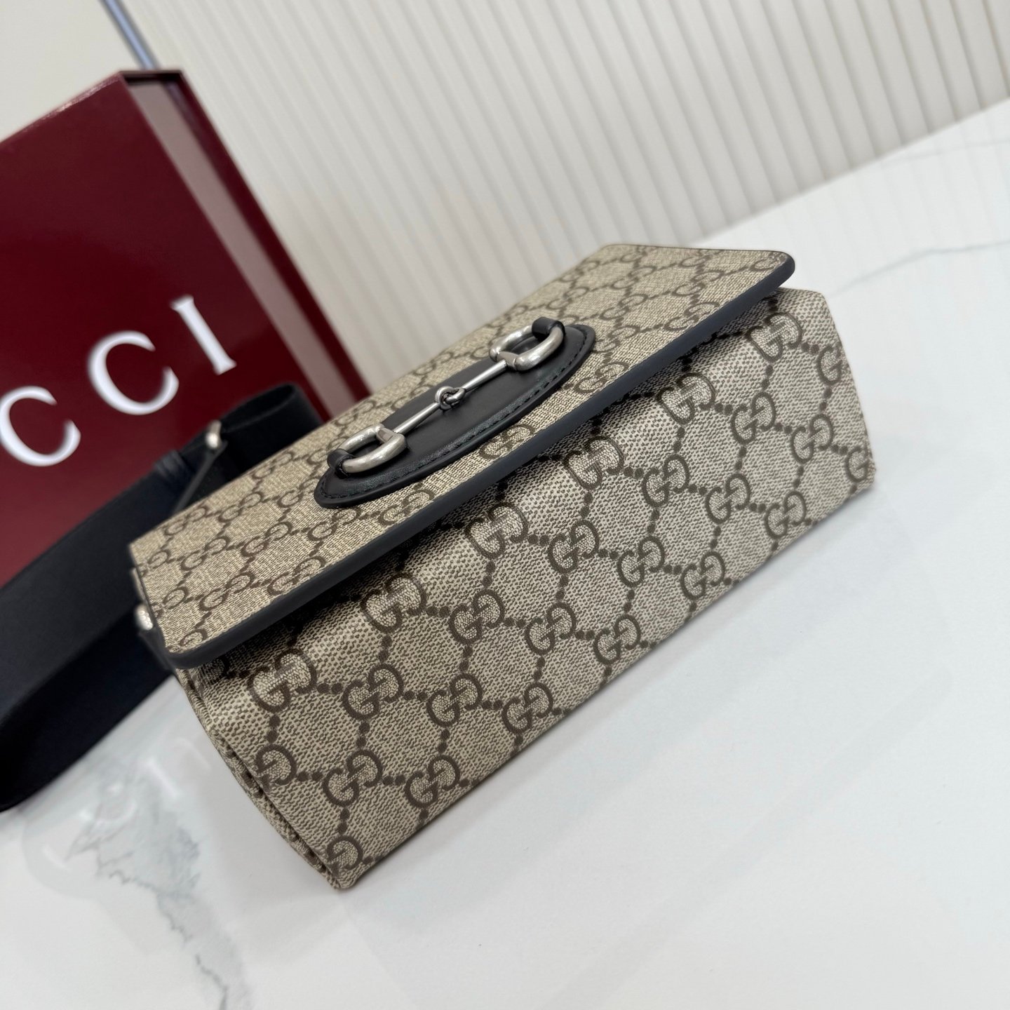 Gucci Horsebit 1955系列推出一款方形剪裁迷你手袋。这款手袋专为收纳常用小物打造，黑色皮革滚边和银色调配件散发别致情调。