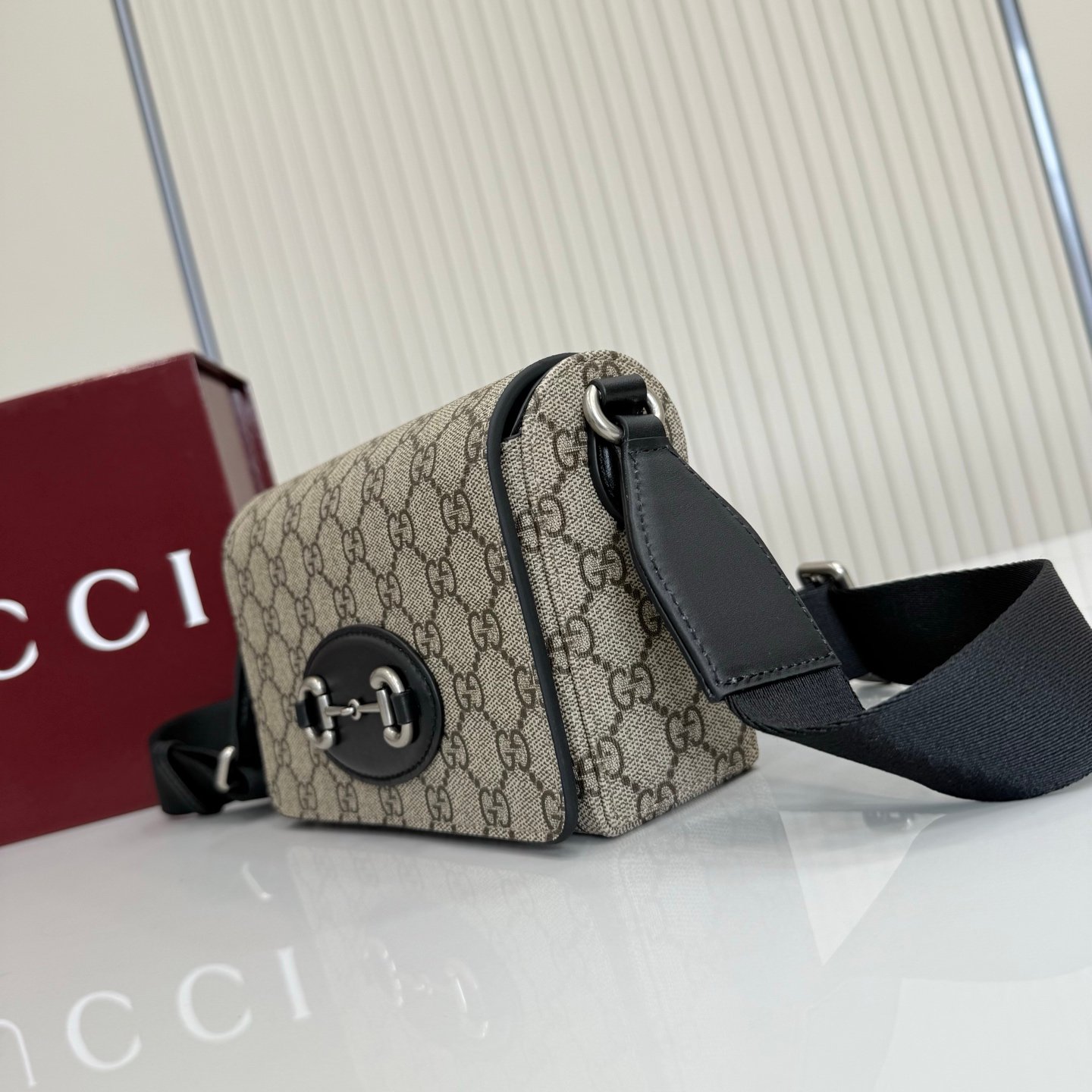 Gucci Horsebit 1955系列推出一款方形剪裁迷你手袋。这款手袋专为收纳常用小物打造，黑色皮革滚边和银色调配件散发别致情调。