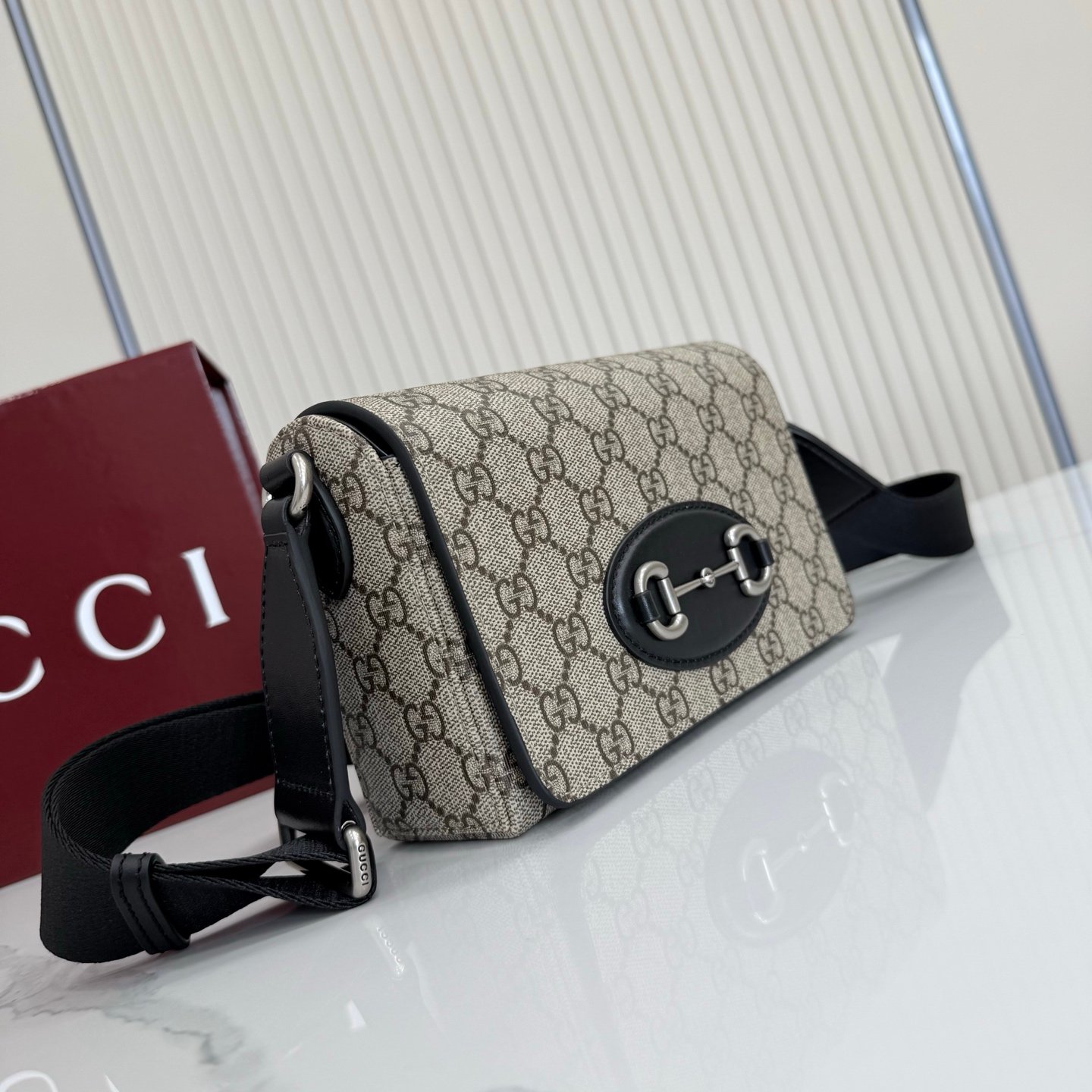 Gucci Horsebit 1955系列推出一款方形剪裁迷你手袋。这款手袋专为收纳常用小物打造，黑色皮革滚边和银色调配件散发别致情调。