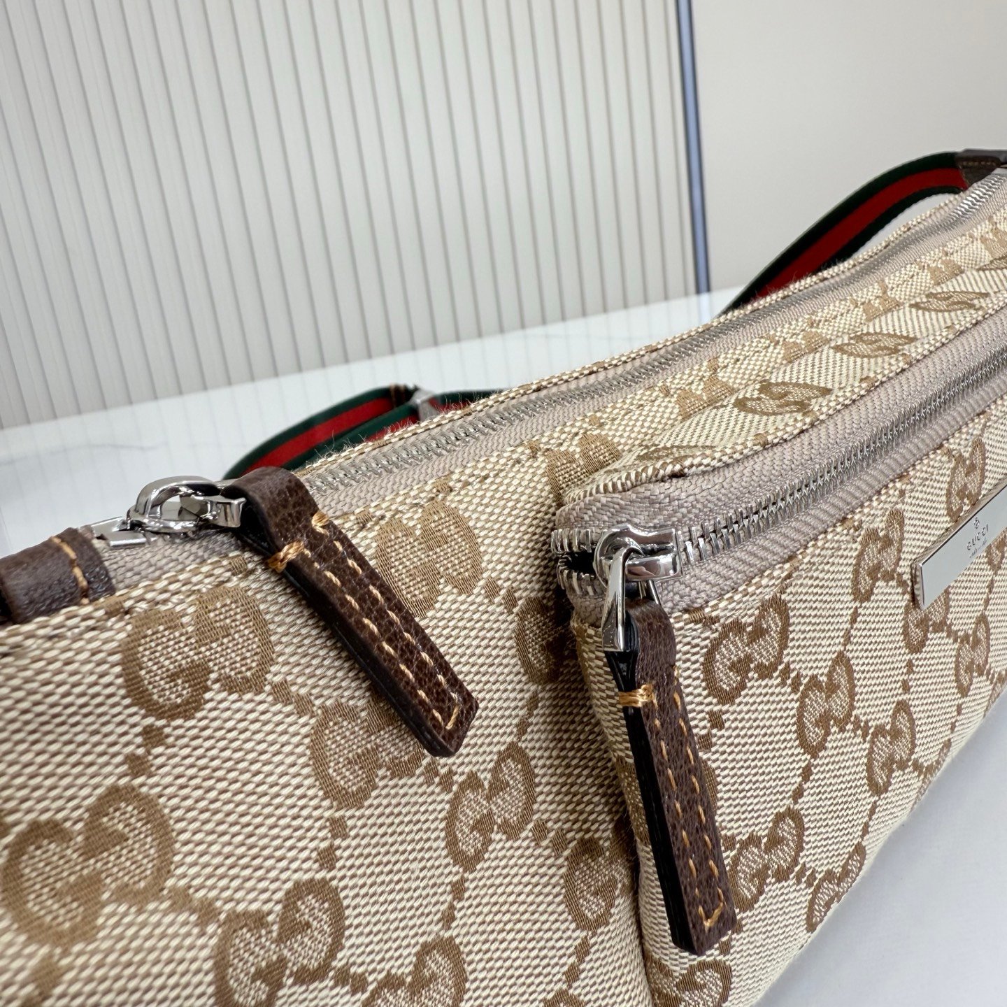 这件单品出自Gucci Primavera系列。Gucci Tag系列的设计同步城市节奏。经典GG帆布面料贯穿于多功能迷你手袋的廓形设计中，并缀饰“Gucci Made in Italy”金属标签，令整款单品更加精致。