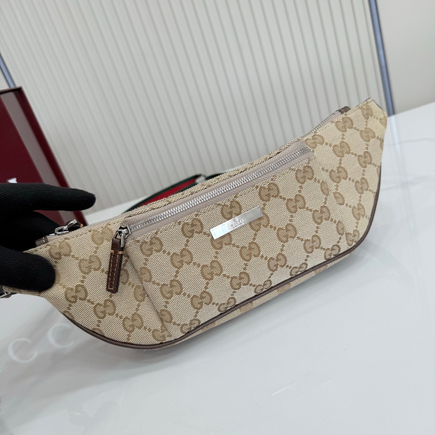 这件单品出自Gucci Primavera系列。Gucci Tag系列的设计同步城市节奏。经典GG帆布面料贯穿于多功能迷你手袋的廓形设计中，并缀饰“Gucci Made in Italy”金属标签，令整款单品更加精致。