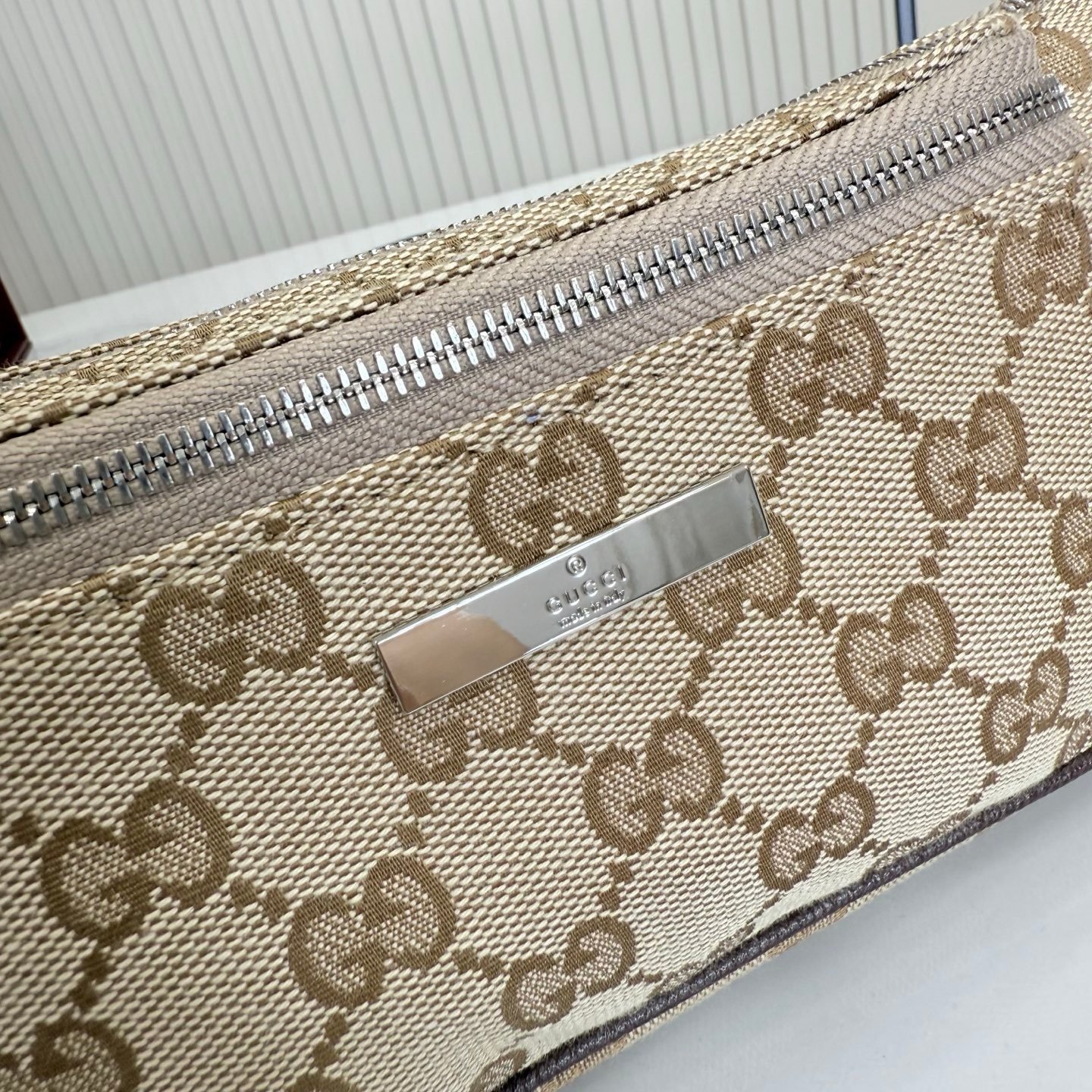 这件单品出自Gucci Primavera系列。Gucci Tag系列的设计同步城市节奏。经典GG帆布面料贯穿于多功能迷你手袋的廓形设计中，并缀饰“Gucci Made in Italy”金属标签，令整款单品更加精致。