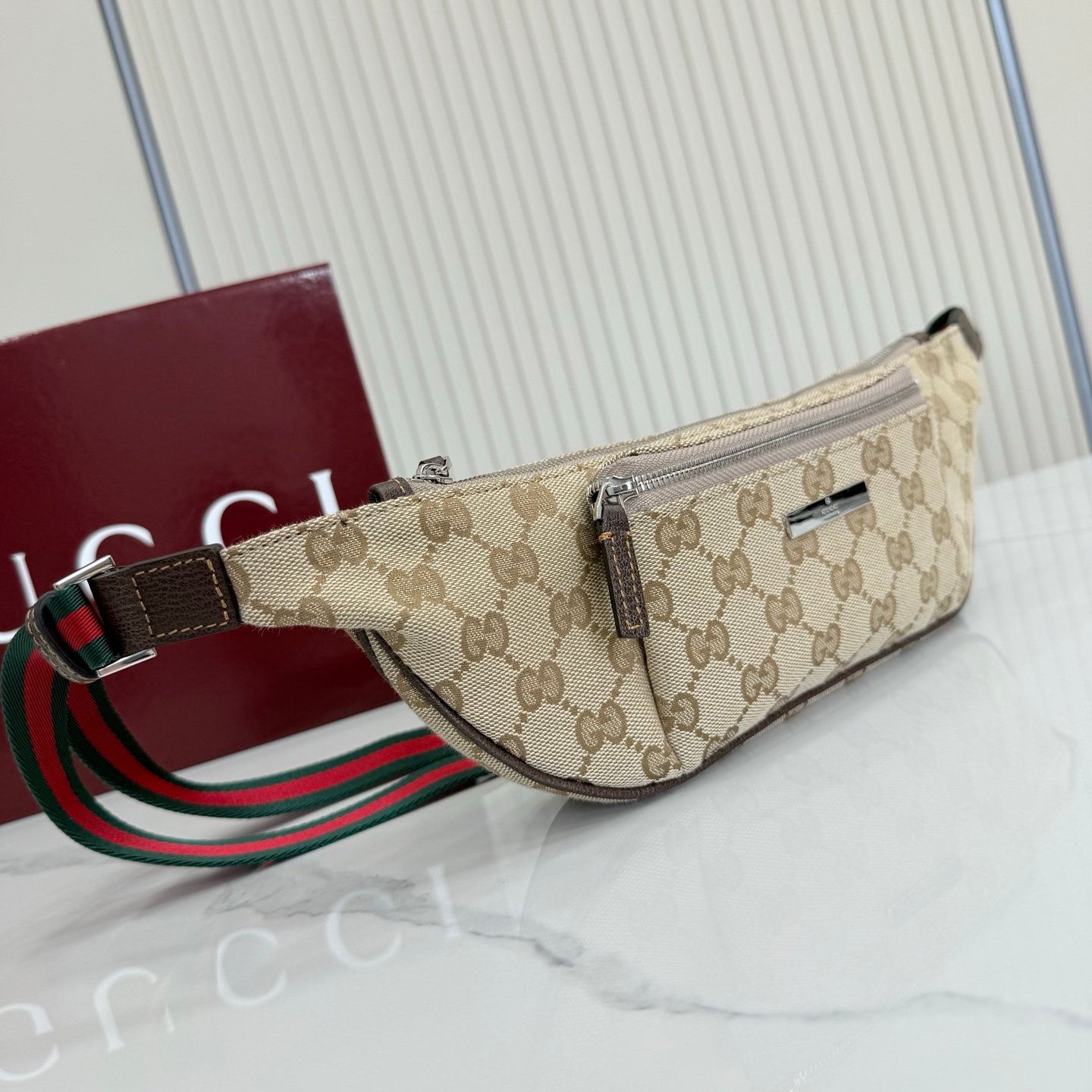 这件单品出自Gucci Primavera系列。Gucci Tag系列的设计同步城市节奏。经典GG帆布面料贯穿于多功能迷你手袋的廓形设计中，并缀饰“Gucci Made in Italy”金属标签，令整款单品更加精致。