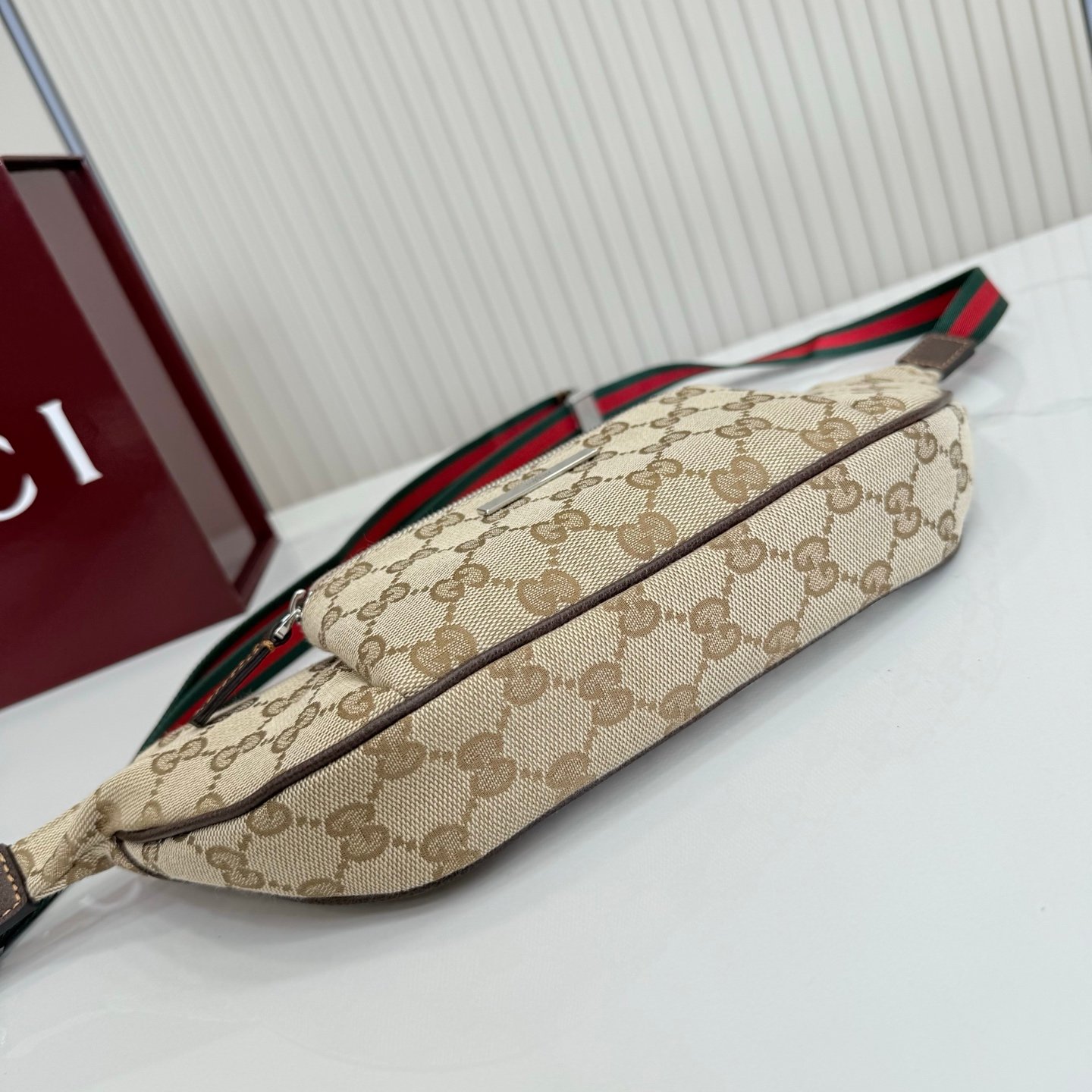 这件单品出自Gucci Primavera系列。Gucci Tag系列的设计同步城市节奏。经典GG帆布面料贯穿于多功能迷你手袋的廓形设计中，并缀饰“Gucci Made in Italy”金属标签，令整款单品更加精致。