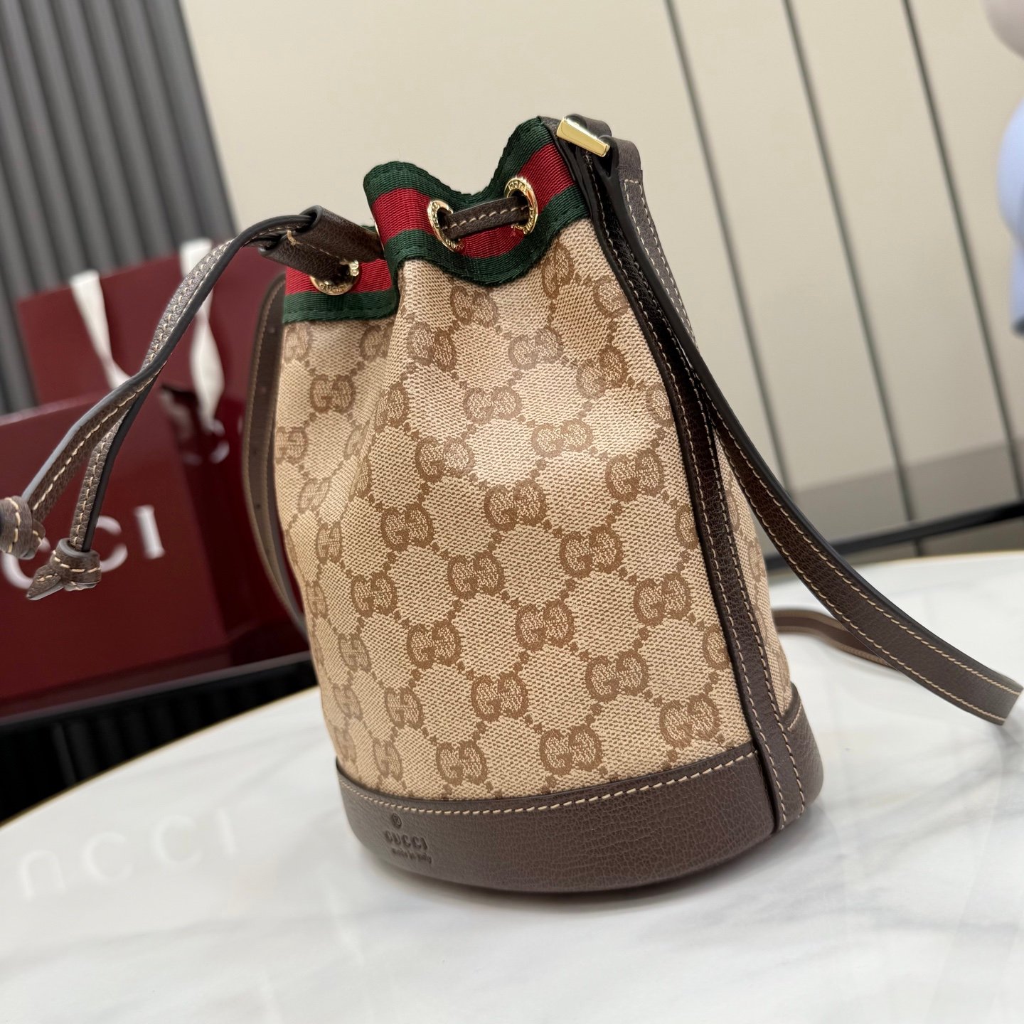 配全套原厂专柜包装 Generation Gucci古驰世代系列深入探索品牌的典藏元素，将不同世代的设计融合为统一的美学叙事。GG涂层帆布搭配经典织带，为多功能小型皮具带来标志性风格，如这款设计用于存放日常必需品的水桶包。