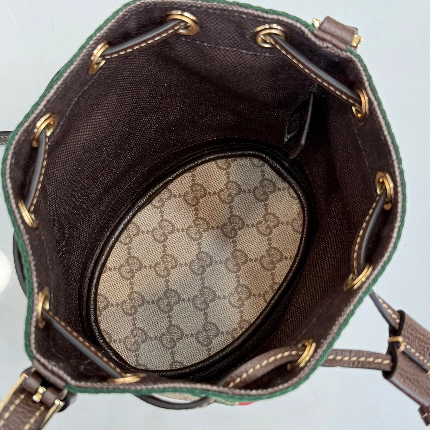 配全套原厂专柜包装 Generation Gucci古驰世代系列深入探索品牌的典藏元素，将不同世代的设计融合为统一的美学叙事。GG涂层帆布搭配经典织带，为多功能小型皮具带来标志性风格，如这款设计用于存放日常必需品的水桶包。