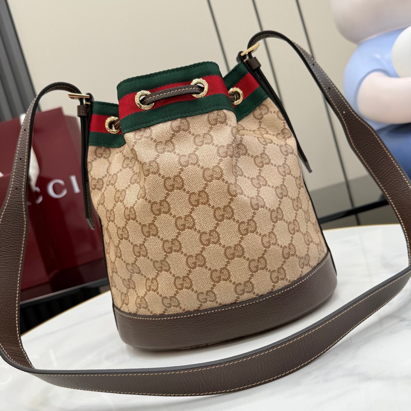 配全套原厂专柜包装 Generation Gucci系列深入探索品牌的经典元素,将不同世代的设计融合成一种美学叙事。GG涂层帆布搭配织带,为多功能小型皮具带来品牌标志性的设计,例如这款设计用于存放日常必需品的水桶包。