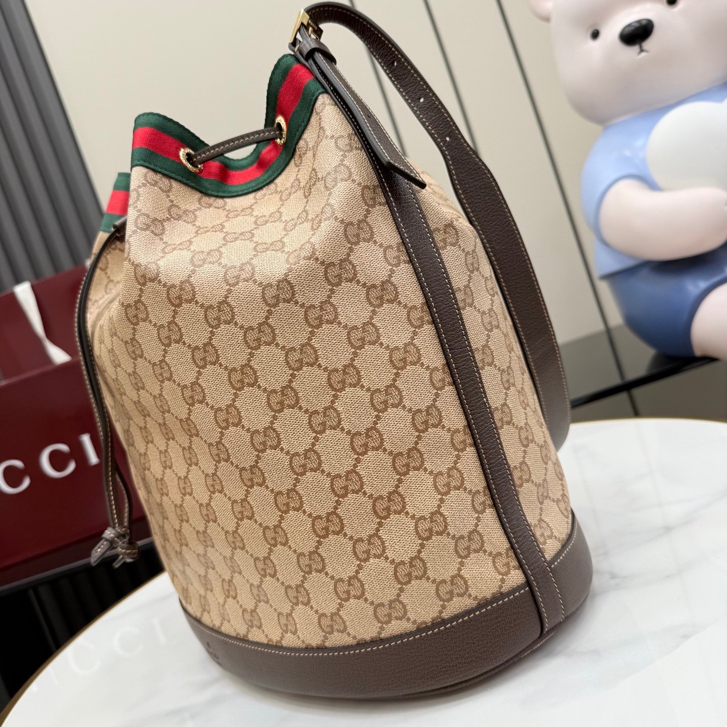 配全套原厂专柜包装 Generation Gucci系列深入探索品牌的经典元素,将不同世代的设计融合成一种美学叙事。GG涂层帆布搭配织带,为多功能小型皮具带来品牌标志性的设计,例如这款设计用于存放日常必需品的水桶包。