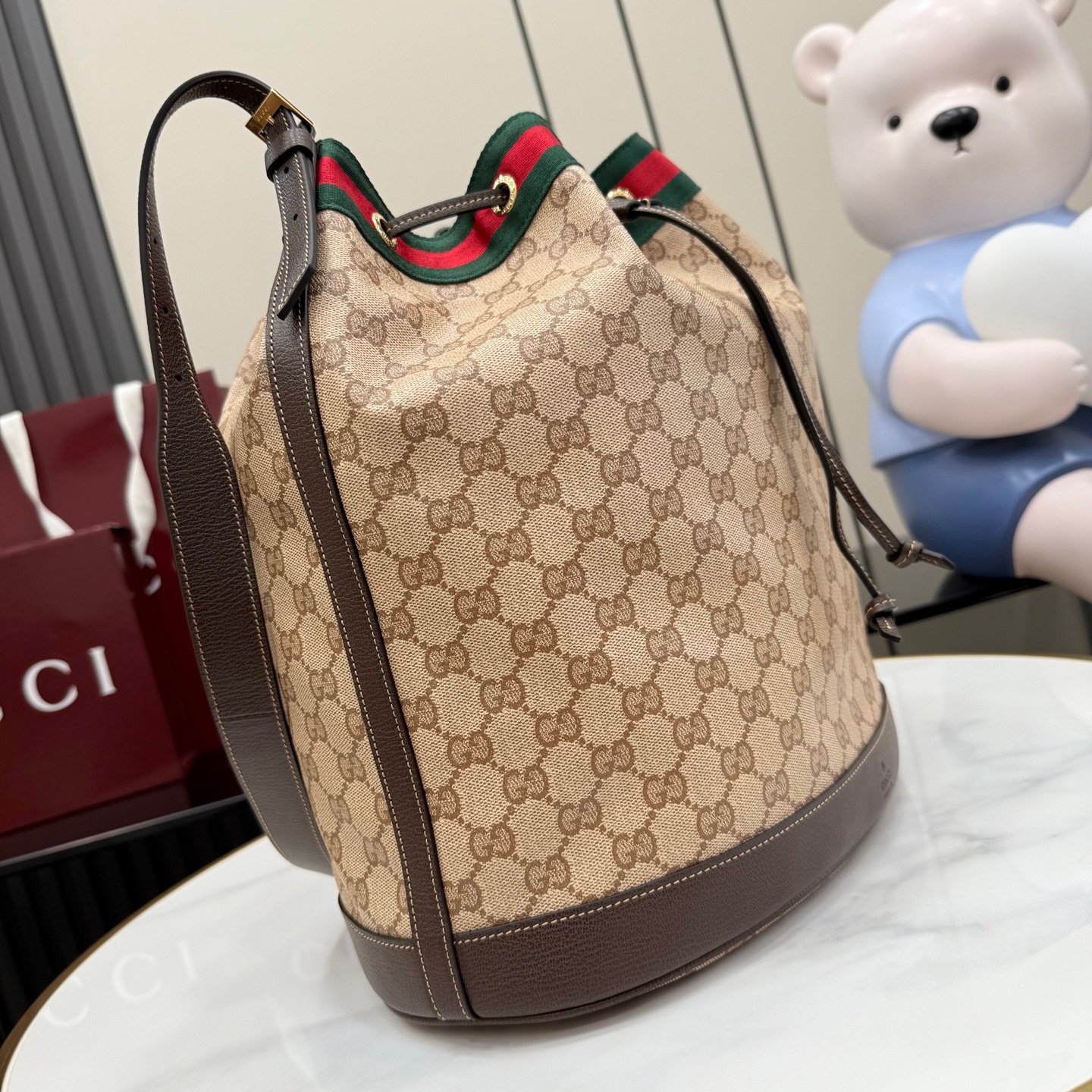 配全套原厂专柜包装 Generation Gucci系列深入探索品牌的经典元素,将不同世代的设计融合成一种美学叙事。GG涂层帆布搭配织带,为多功能小型皮具带来品牌标志性的设计,例如这款设计用于存放日常必需品的水桶包。