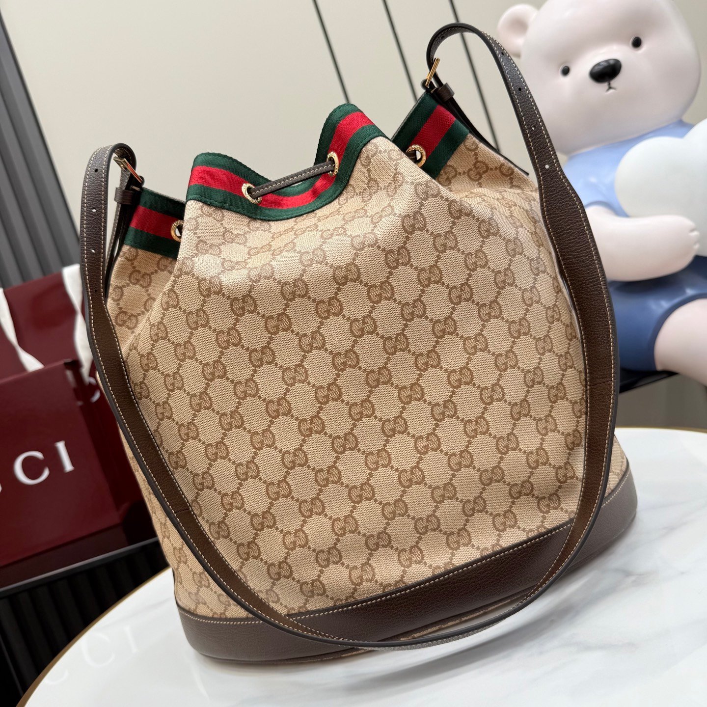 配全套原厂专柜包装 Generation Gucci系列深入探索品牌的经典元素,将不同世代的设计融合成一种美学叙事。GG涂层帆布搭配织带,为多功能小型皮具带来品牌标志性的设计,例如这款设计用于存放日常必需品的水桶包。