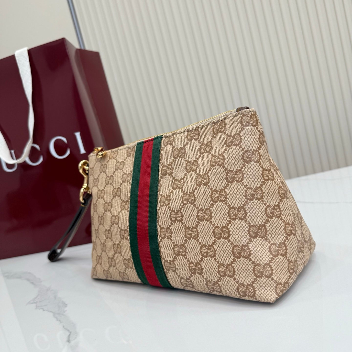 Generation Gucci古驰世代系列深入探索品牌的典藏元素，将不同世代的设计融合为统一的美学叙事，推出全新小皮具系列，以GG涂层帆布为基础，饰有显眼的织带细节。搭配皮革滚边，这款多功能款式采用无衬里设计，呈现出时尚轻盈的外观。