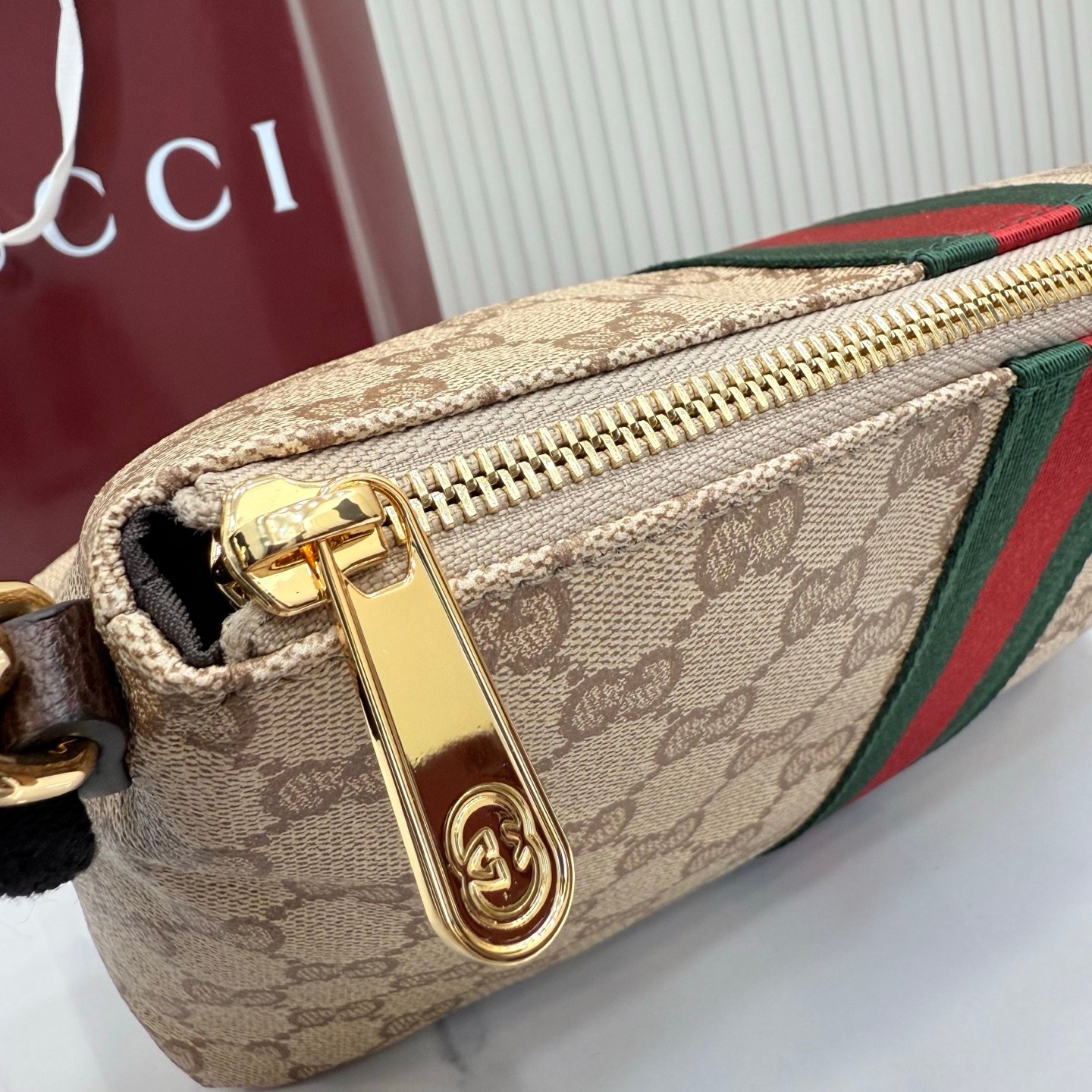 Generation Gucci古驰世代系列深入探索品牌的典藏元素，将不同世代的设计融合为统一的美学叙事，推出全新小皮具系列，以GG涂层帆布为基础，饰有显眼的织带细节。搭配皮革滚边，这款多功能款式采用无衬里设计，呈现出时尚轻盈的外观。
