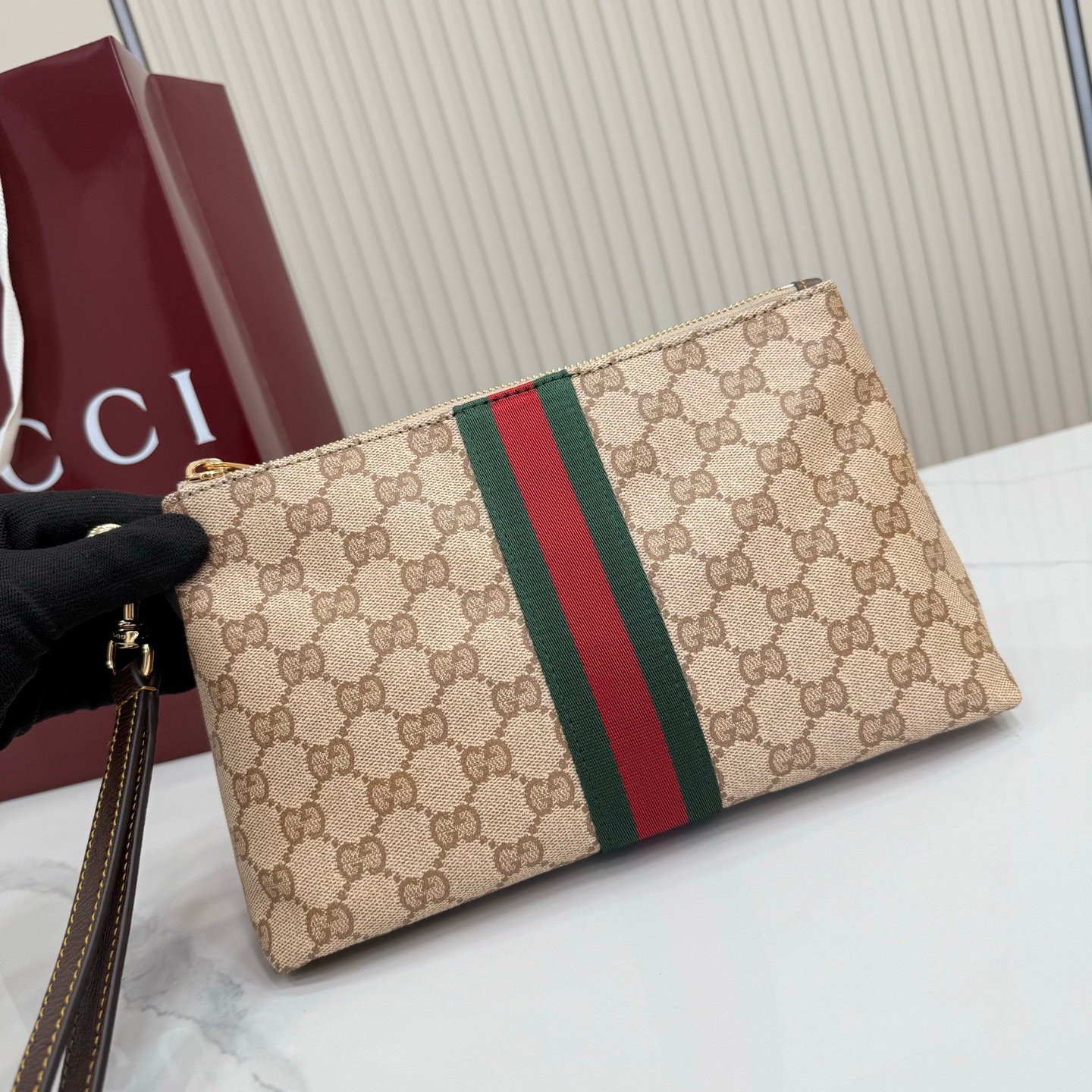 Generation Gucci古驰世代系列深入探索品牌的典藏元素，将不同世代的设计融合为统一的美学叙事，推出全新小皮具系列，以GG涂层帆布为基础，饰有显眼的织带细节。搭配皮革滚边，这款多功能款式采用无衬里设计，呈现出时尚轻盈的外观。