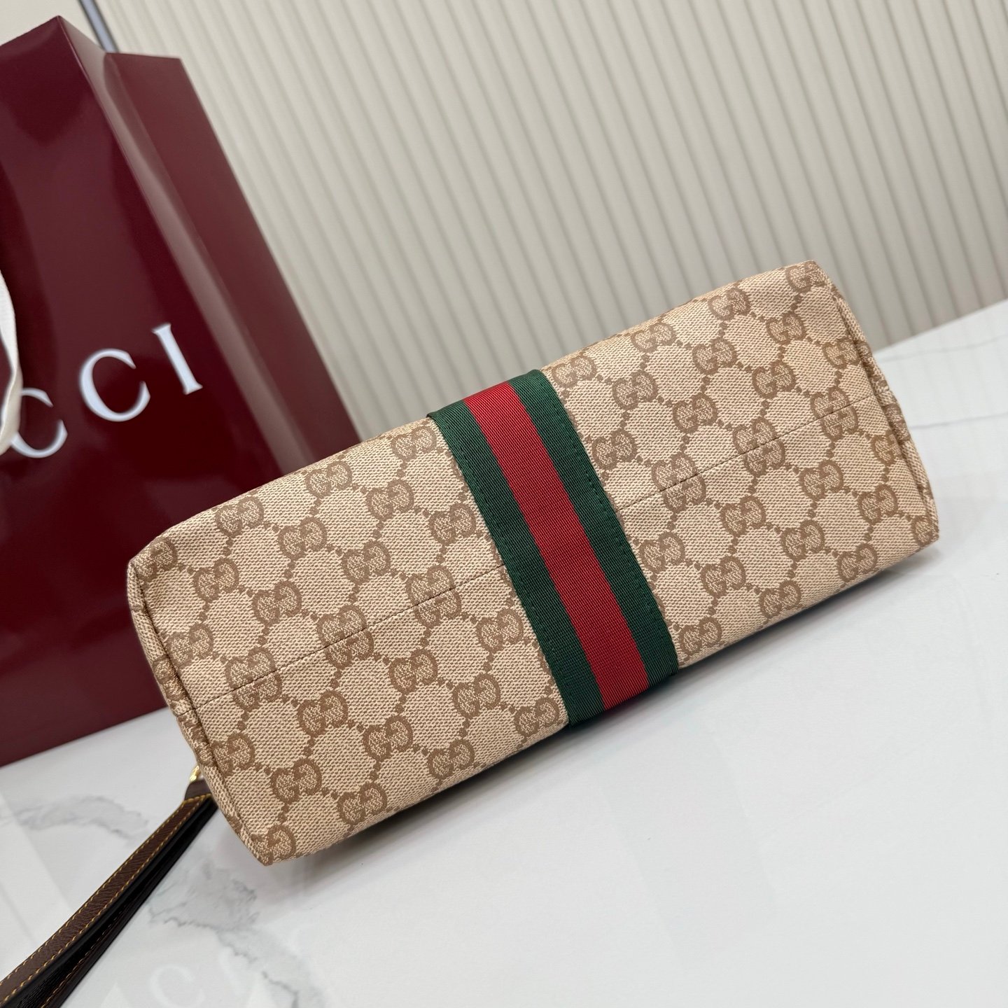 Generation Gucci古驰世代系列深入探索品牌的典藏元素，将不同世代的设计融合为统一的美学叙事，推出全新小皮具系列，以GG涂层帆布为基础，饰有显眼的织带细节。搭配皮革滚边，这款多功能款式采用无衬里设计，呈现出时尚轻盈的外观。
