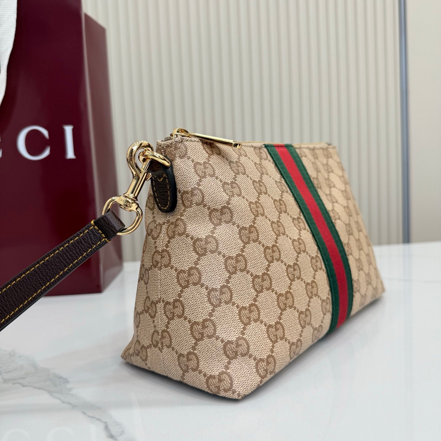 Generation Gucci古驰世代系列深入探索品牌的典藏元素，将不同世代的设计融合为统一的美学叙事，推出全新小皮具系列，以GG涂层帆布为基础，饰有显眼的织带细节。搭配皮革滚边，这款多功能款式采用无衬里设计，呈现出时尚轻盈的外观。