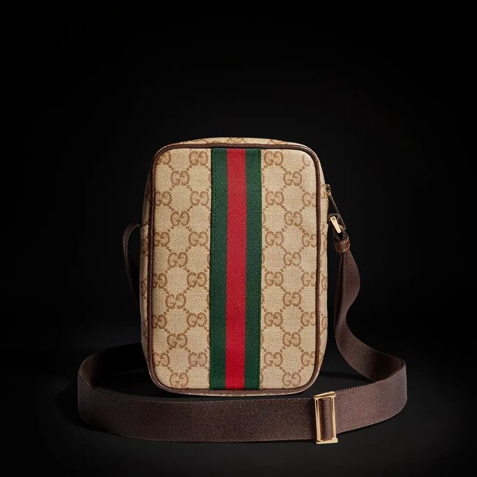 Generation Gucci古驰世代系列深入探索品牌的典藏元素，将不同世代的设计融合为统一的美学叙事，推出全新小皮具系列，以GG涂层帆布为基础，饰有显眼的织带细节。搭配皮革滚边，这款多功能款式采用无衬里设计，呈现出时尚轻盈的外观。