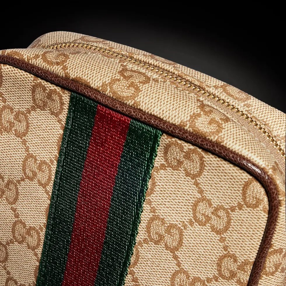 Generation Gucci古驰世代系列深入探索品牌的典藏元素，将不同世代的设计融合为统一的美学叙事，推出全新小皮具系列，以GG涂层帆布为基础，饰有显眼的织带细节。搭配皮革滚边，这款多功能款式采用无衬里设计，呈现出时尚轻盈的外观。