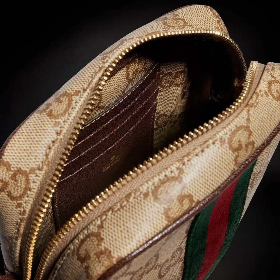 Generation Gucci古驰世代系列深入探索品牌的典藏元素，将不同世代的设计融合为统一的美学叙事，推出全新小皮具系列，以GG涂层帆布为基础，饰有显眼的织带细节。搭配皮革滚边，这款多功能款式采用无衬里设计，呈现出时尚轻盈的外观。