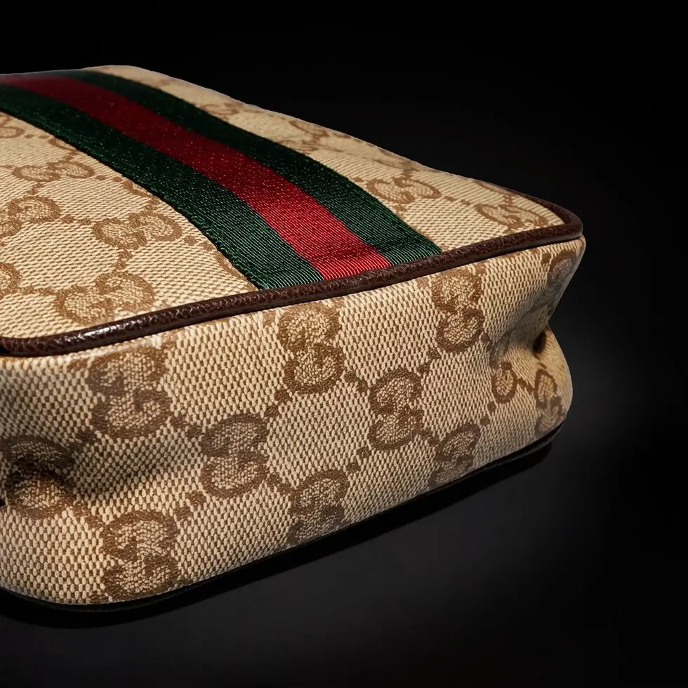 Generation Gucci古驰世代系列深入探索品牌的典藏元素，将不同世代的设计融合为统一的美学叙事，推出全新小皮具系列，以GG涂层帆布为基础，饰有显眼的织带细节。搭配皮革滚边，这款多功能款式采用无衬里设计，呈现出时尚轻盈的外观。