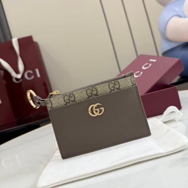 。《配全套原厂专柜包装》Generation Gucci 系列深入探索品牌典藏元素，将不同年代的设计融合于一体，呈现出独特的美学叙事。GG Marmont 系列包含双色款式，如这款配有标志性双G造型配件的拉链钥匙包。